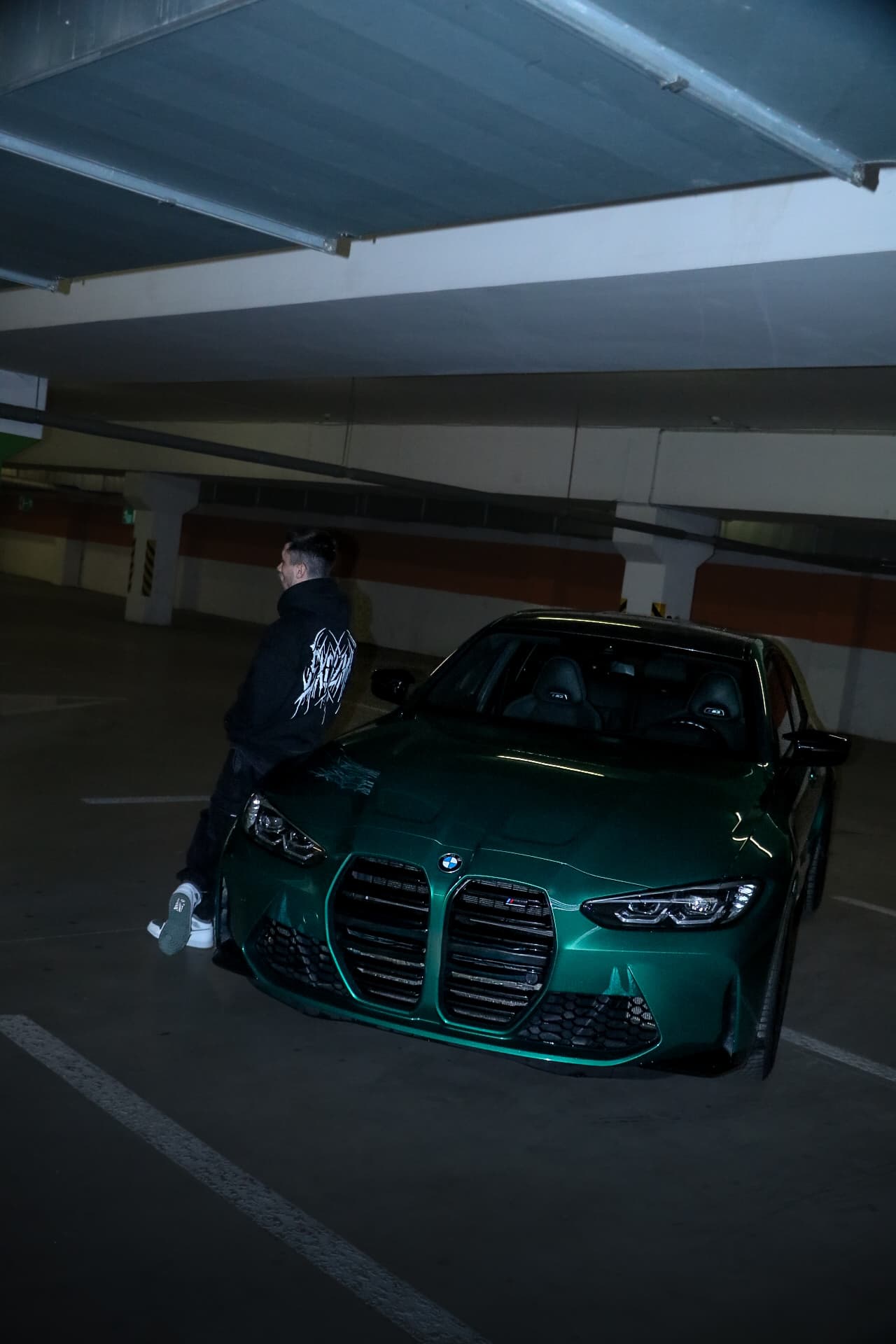Black Excuzme hoodie in a wide editorial shot.