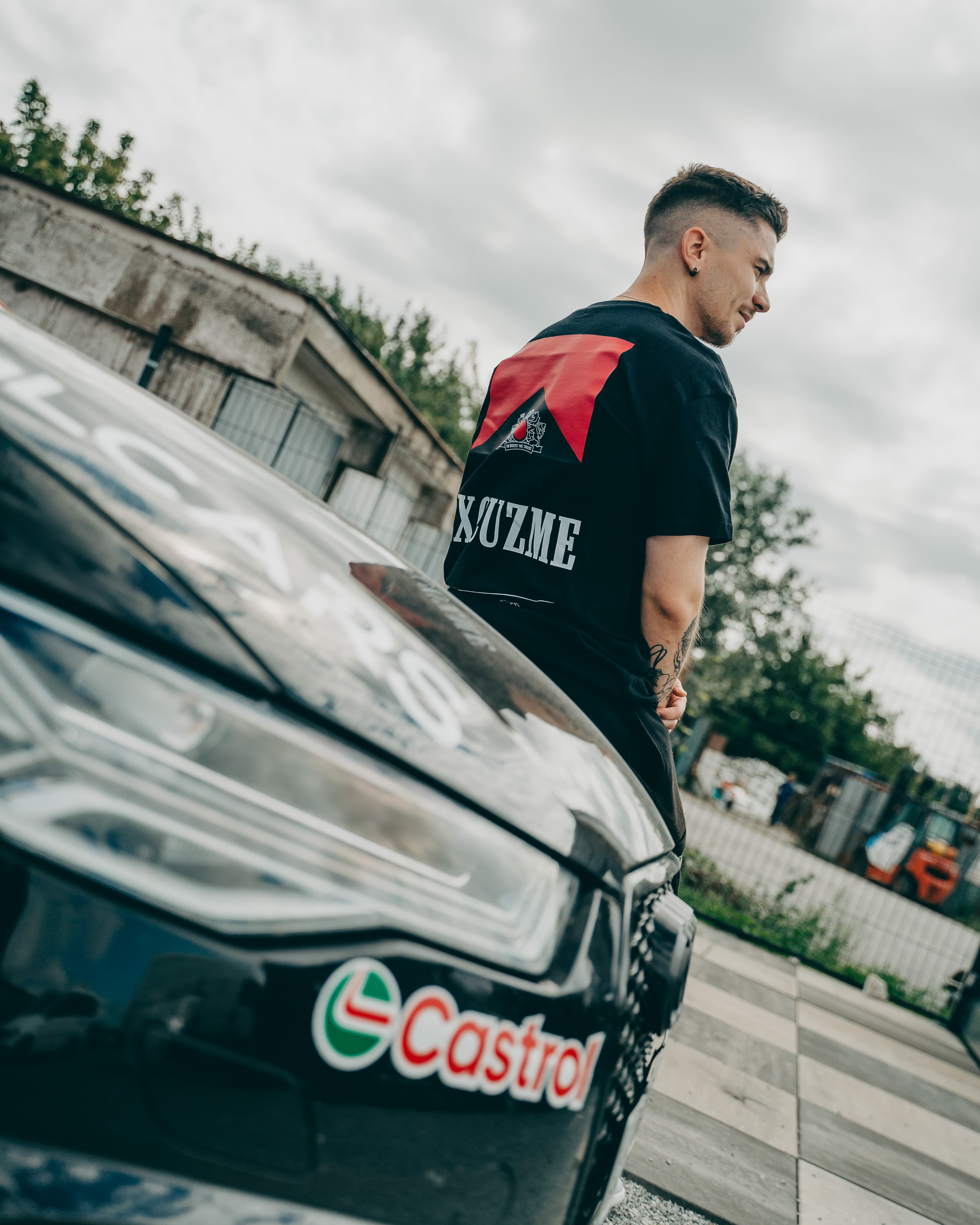 Filtered For Speed tee shown from a back angle near a car.