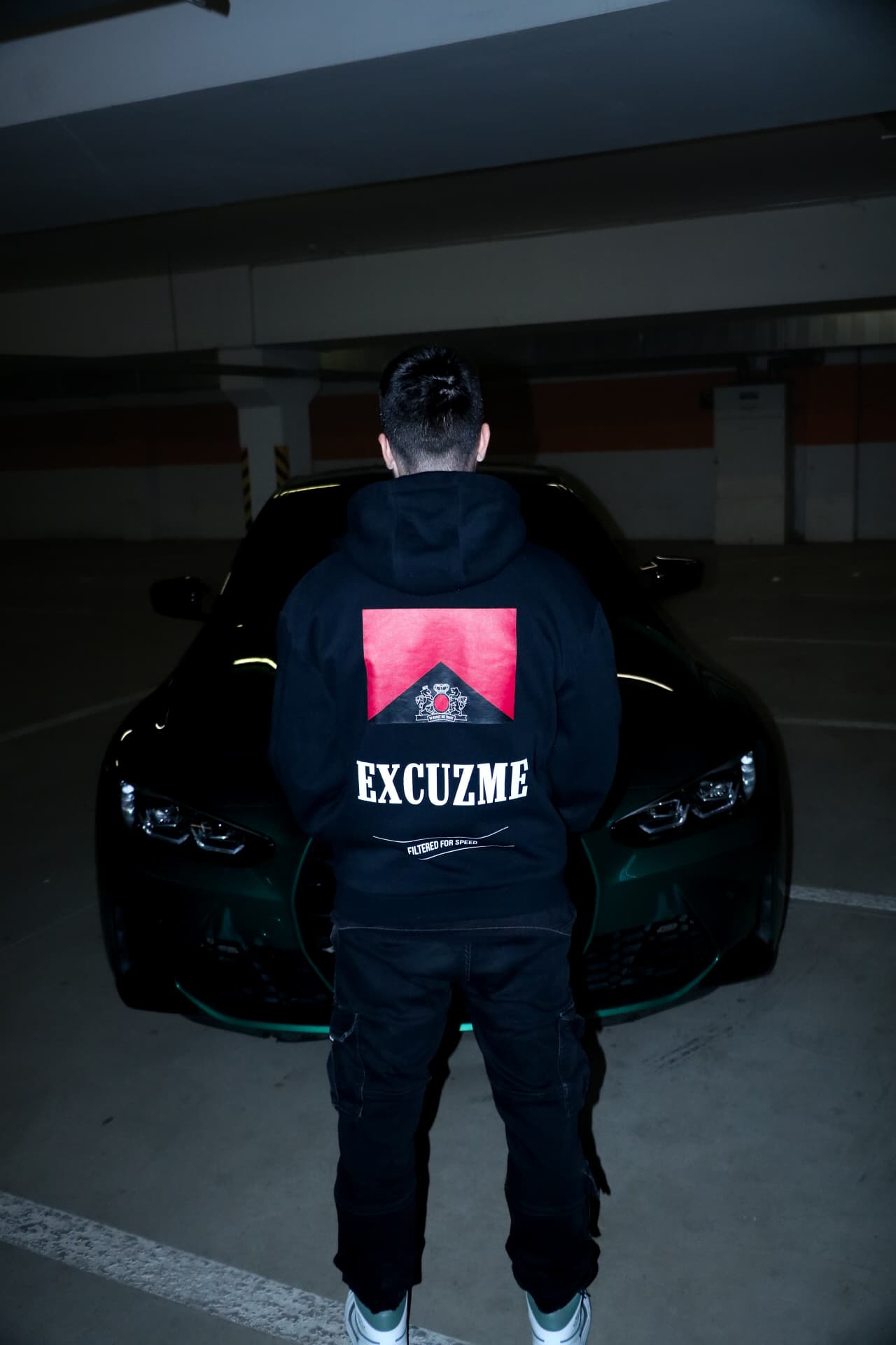 Filtered For Speed hoodie zozadu pred zeleným autom.