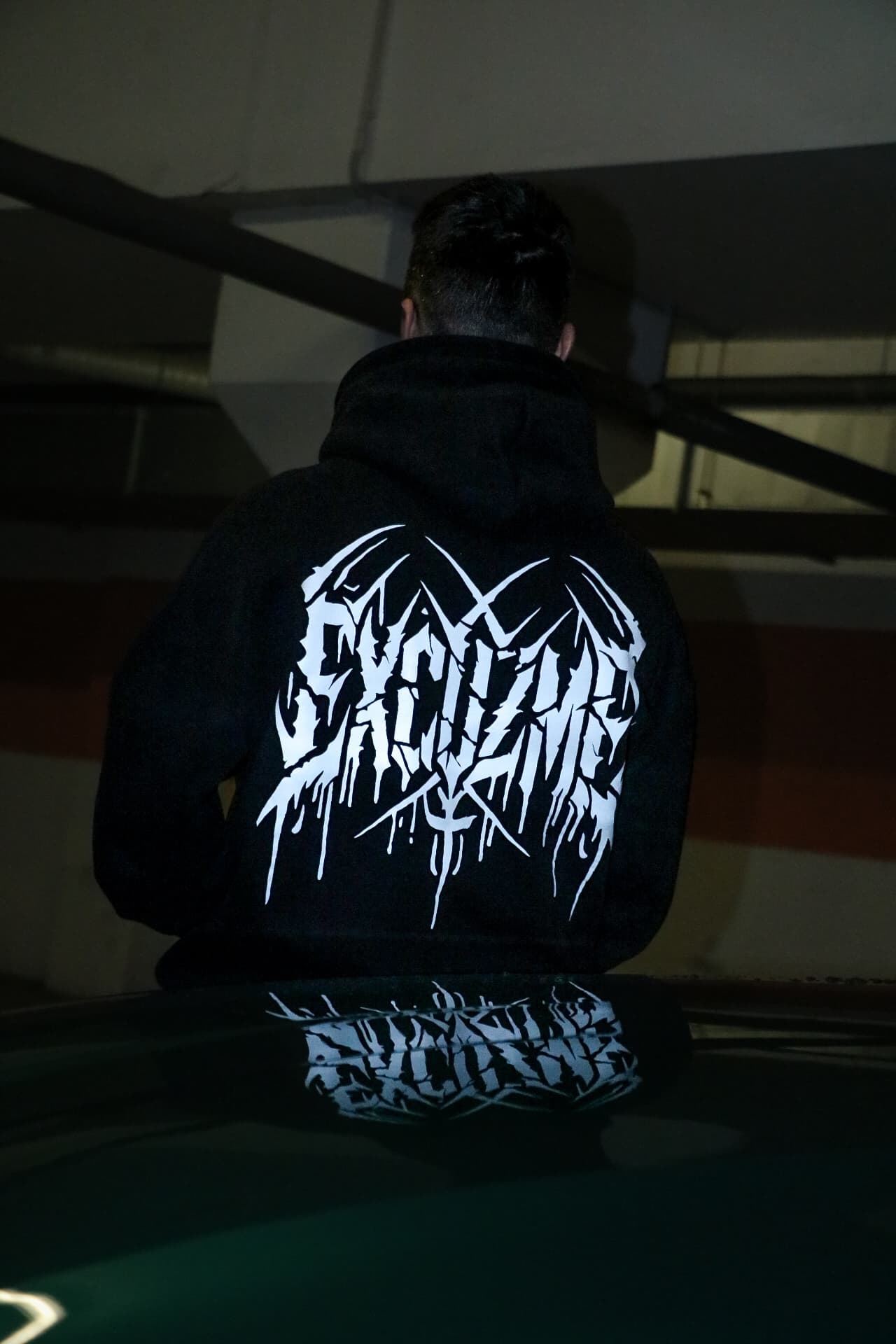 Chaos Backprint hoodie reflected in a moody editorial shot.